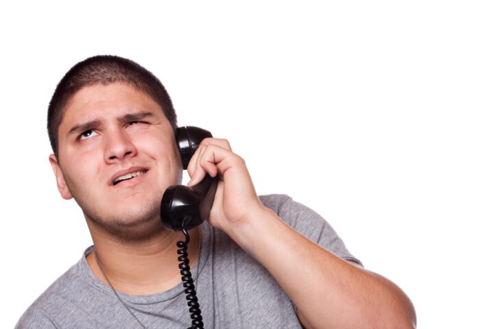 Ein Mann, der geduldig einem nervigen Telefongespräch zuhört